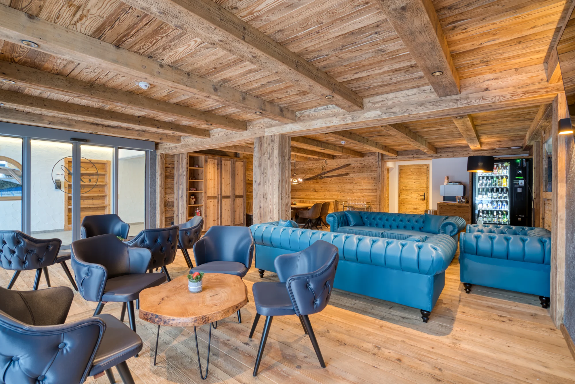 Lounge im Appartement Hofmann mit Naturholz und blauen Sesseln